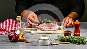 Cooking meat steak, vegetables and spices with by chef hands on wooden background. Food recipe concept