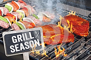 Meat, steaks and sausages on a bbq grill outside with grill season