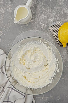 Cooking meringue Pavlova roll cake. Ð¡ream for Pavlova cake of cream cheese, cream, sugar and lemon zest in a bowl