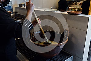 Cooking Mexican Mole food in a traditional clay pot in Mexico