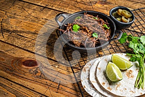 Cooking of mexican pork carnitas taco. Wooden background. Top view. Copy space