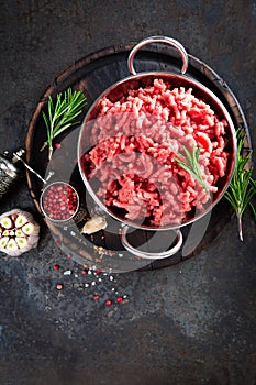 Cooking mince. Raw ground veal meat with ingredients for cooking on black kitchen table. Fresh minced meat