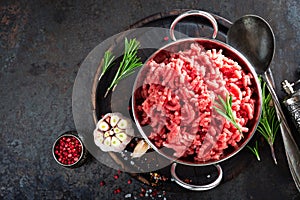 Cooking mince. Raw ground veal meat with ingredients for cooking on black kitchen table. Fresh minced meat