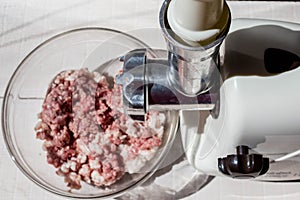 Cooking minced meat at home on an electric meat grinder.