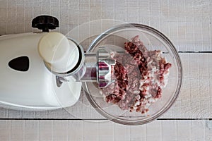 Cooking minced meat at home on an electric meat grinder.