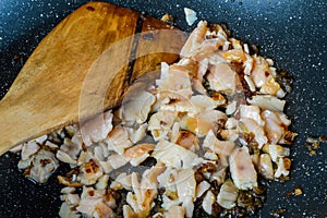 Cooking minced red onions and smoked salmon with olive oil on a frying pan