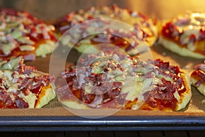 Cooking mini pizzas in an electric oven.