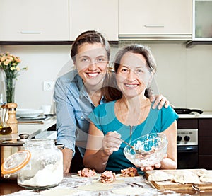 Cooking mother with adult daughter