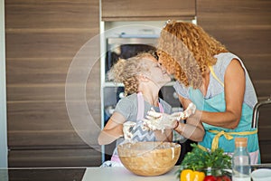 Mother and child daughter girl having fun while making dinner at the kitchen.