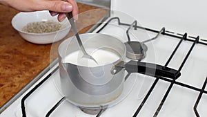 Cooking oatmeal, boiling milk and oatmeal in a plate, close-up, stir with a spoon, cereal