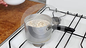 Cooking oatmeal, a woman stir the milk with a spoon and fall asleep oatmeal, close-up, cereal, breakfast