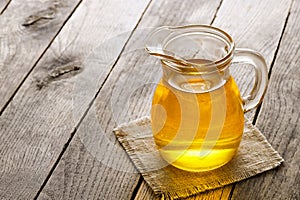 cooking oil in glass jug on wooden table