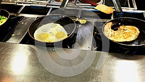 Cooking omelettes and fried eggs. Breakfast buffet in restaurant