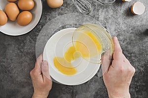 Cooking omlette. Woman& x27;s hands cookingomlette, breaking an fresh egg. Dark background. Food flat lay