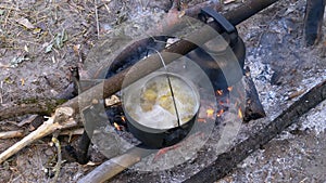 Cooking on an Open Fire in a Tourist Pot. Tourist Bowler Hat Hanging at Bonfire