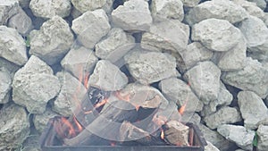 Cooking, oriental cuisine, forest fires, arson concept - lighting fire and coals in black metallic grill for smoking and