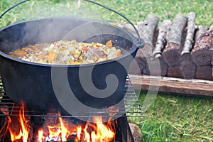 Cooking outdoors in cast iron cauldron