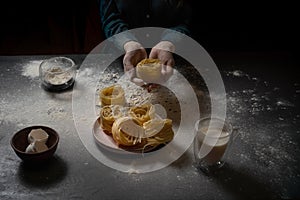 Cooking pasta spaghetti pastry with flour on a dark black background with the outer space.