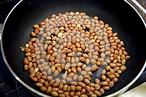 Cooking peanuts in a black pan
