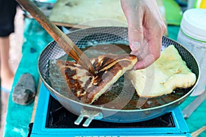 Cooking pies on outdoors. khachapuri or belyash fried in a pan