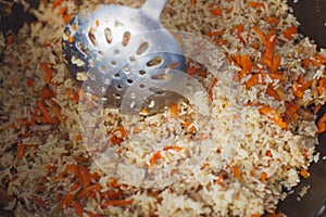 Cooking pilaf with meat and carrots closeup photo