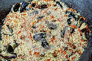 Cooking pilaf with mussels dish in a cauldron, outdoor