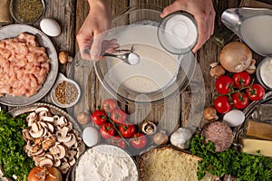 Cooking pizza, the chef makes a pie. Dough preparation, step-by-step process, with ingredients in the background