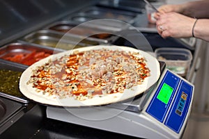 Cooking pizza. Pizza lies on the scales.