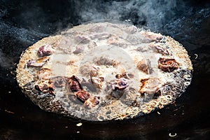 Cooking of plov in the Kazan cauldron at the Central Asian Plov Centre, Tashkent, Uzbekistan