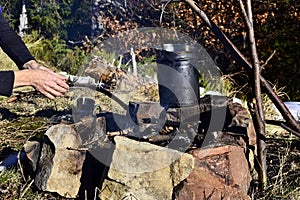 Cooking in a pot over campfire in the mountains