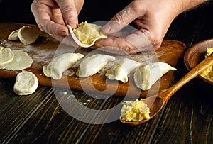 Cooking potato dumplings with the hands of a chef in the kitchen. Close-up of a cook hands while working on a kitchen table with