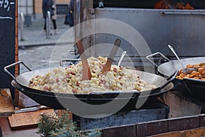 Cooking of potato dumplings with sheep cheese and bacon at Christmas market on the Cabbage Market Brno, Czech Republic