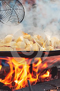 Cooking potatoes with eggs on an open fire