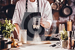 Cooking, profession and people concept - male chef cook making food at restaurant kitchen