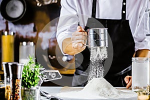 Cooking, profession and people concept - male chef cook making food at restaurant kitchen