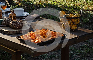 Cooking pumpkin pie, soup and table setting in the garden on the background of homemade bread with  seeds and decorative pu