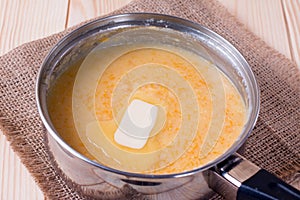 Cooking pumpkin porridge with a slice of butter