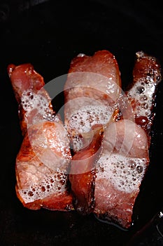 Cooking rashers bacon on a pan photo