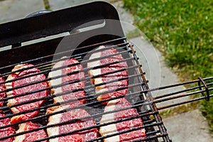 Cooking raw steaks on a barbecue grill