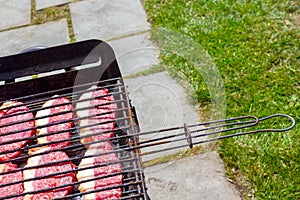 Cooking raw steaks on a barbecue grill