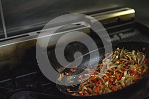 Cooking in a restaurant onion and red pepper.