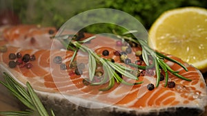 Cooking salmon steak. piece of salmon sprinkled with salt, pepper, spices and rosemary