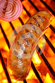 Cooking a sausage hot dog on barbecue grill