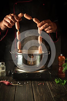 Cooking sausages by the chef in the kitchen. Menu for a restaurant or hotel