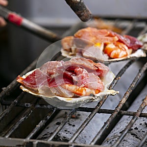 Cooking seafood at a food stall at the Tsukiji Outer Market in the city of Tokyo, Japan.