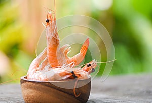 Cooking seafood shrimps prawns served on a wooden bowl with nature background - fresh shrimp