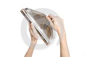 Cooking and shisha topic: human hand holding a foil isolated on white background in studio