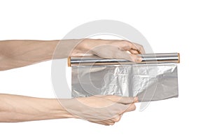 Cooking and shisha topic: human hand holding a foil isolated on white background in studio