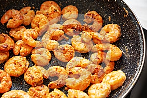 Cooking shrimps on a frypan, side view. Close-up
