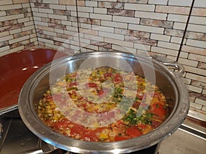 Cooking soup in a metal pan on a gas stove, chicken vegetable soup